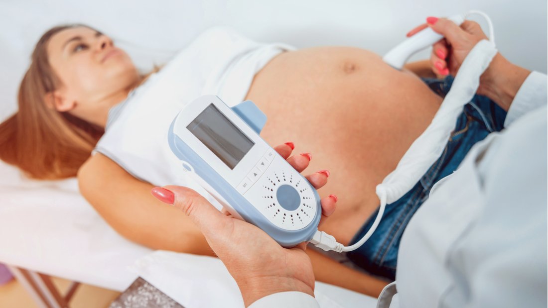 A fetal Doppler being used on a pregnant woman.