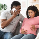 Couple with man calling the midwife