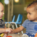 Two babies holding hands